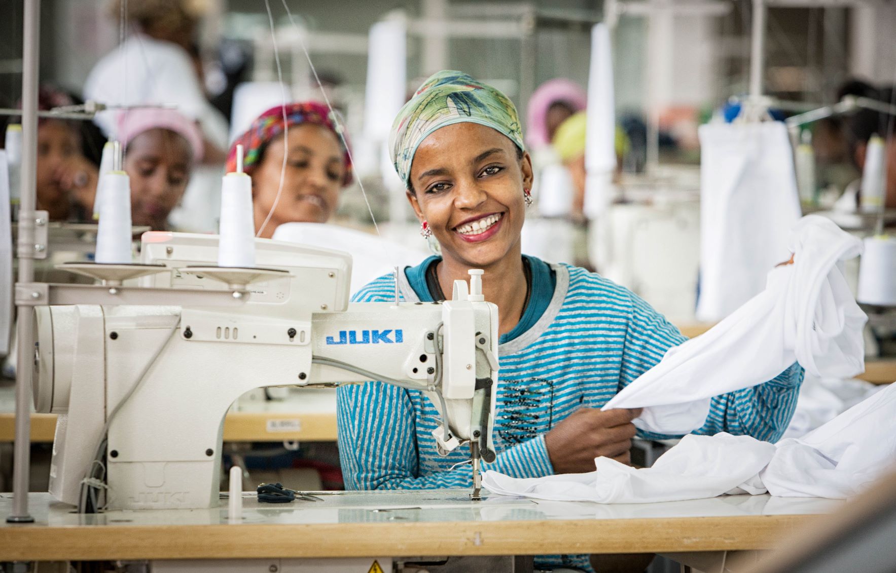 vrouw aan het werk achter de naaimachine in textielfabriek