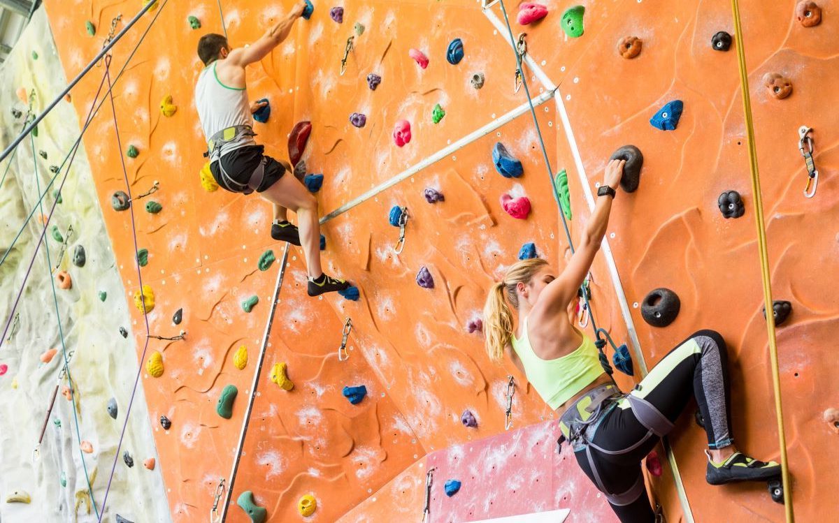Een man en een vrouw op een indoor klimwand.